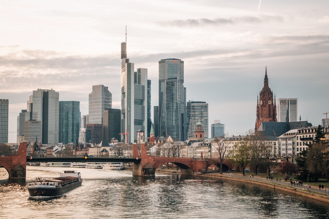 Modern skyscrapers and historic buildings on riverbank.