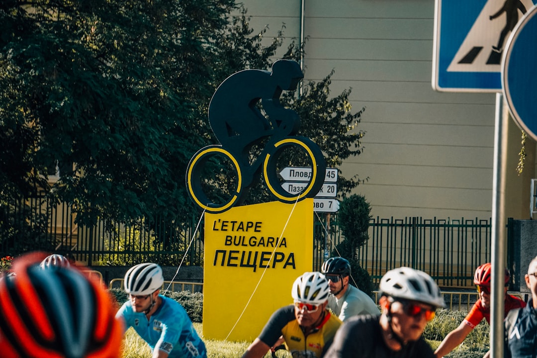 Cyclists near a large black silhouette of a cyclist.